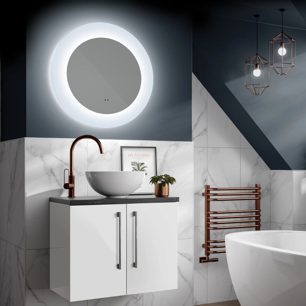 Lifestyle image of the hib. Cassini Round 600mm Deep Border LED Mirror mounted above a white countertop basin and vanity unit